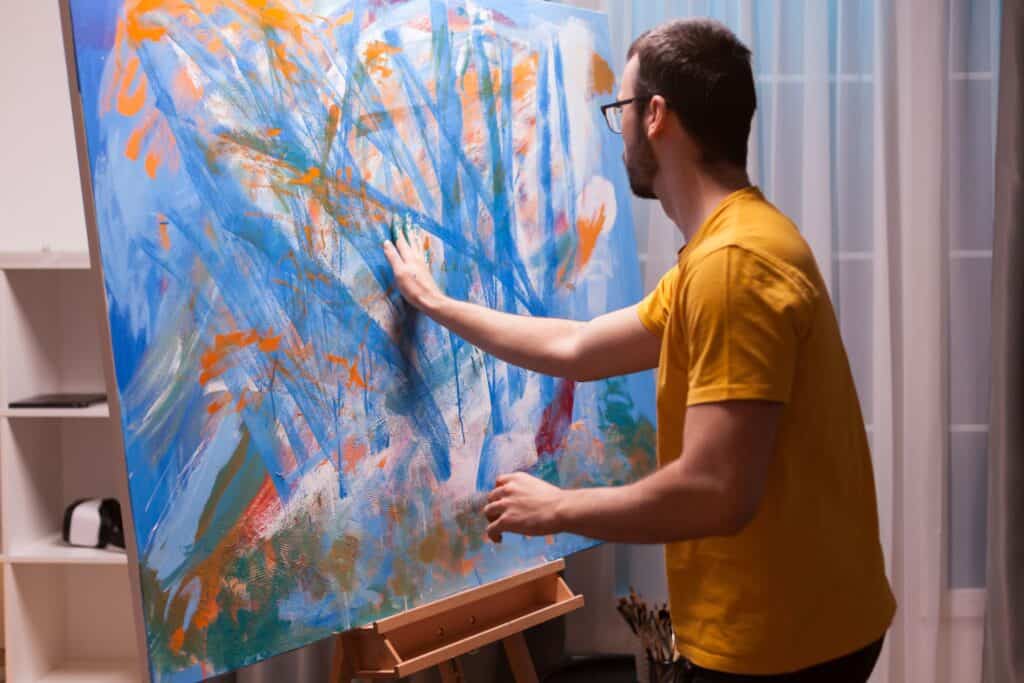 A man is painting on canvas