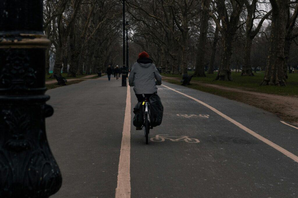 A person on the cycling path of a park on a gloomy day