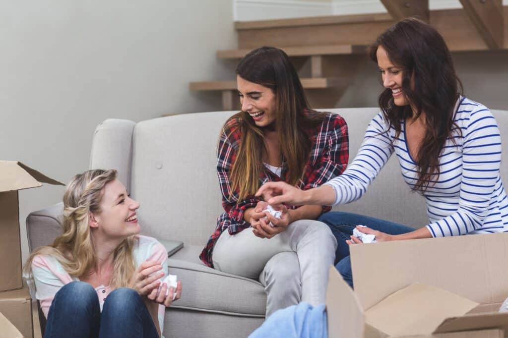 Friends interacting in their new house after the move in the concept of 'how to save money when moving to Slough'.