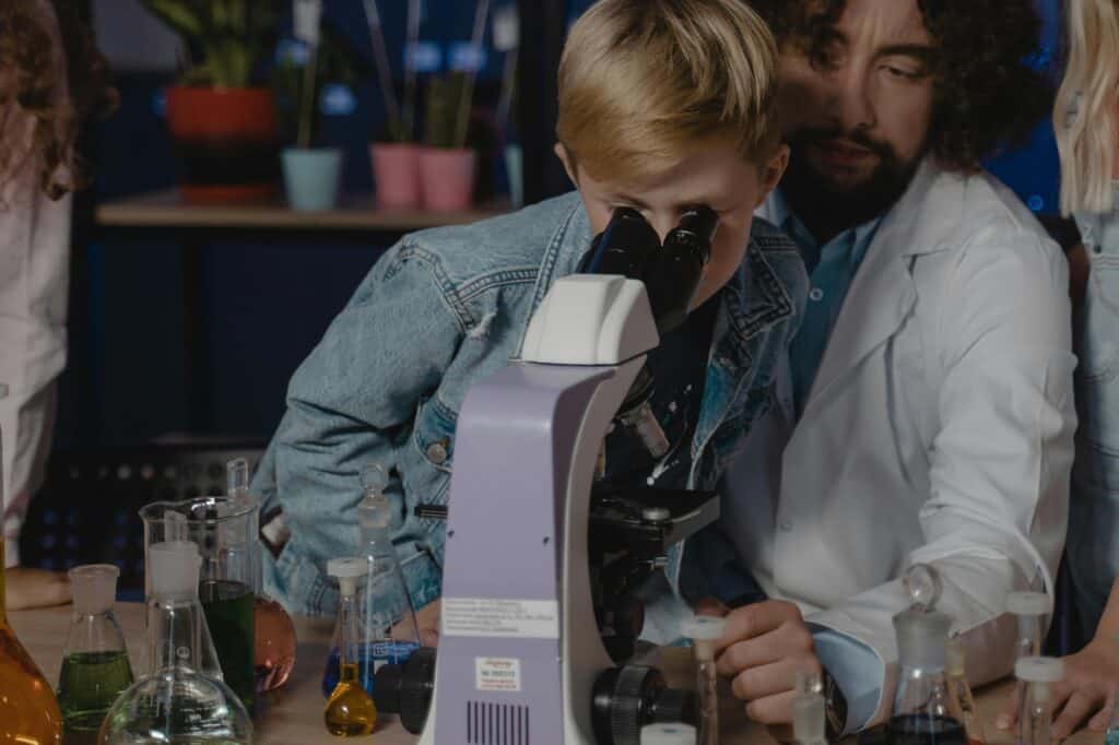 A young male student is using the microscope in the laboratory