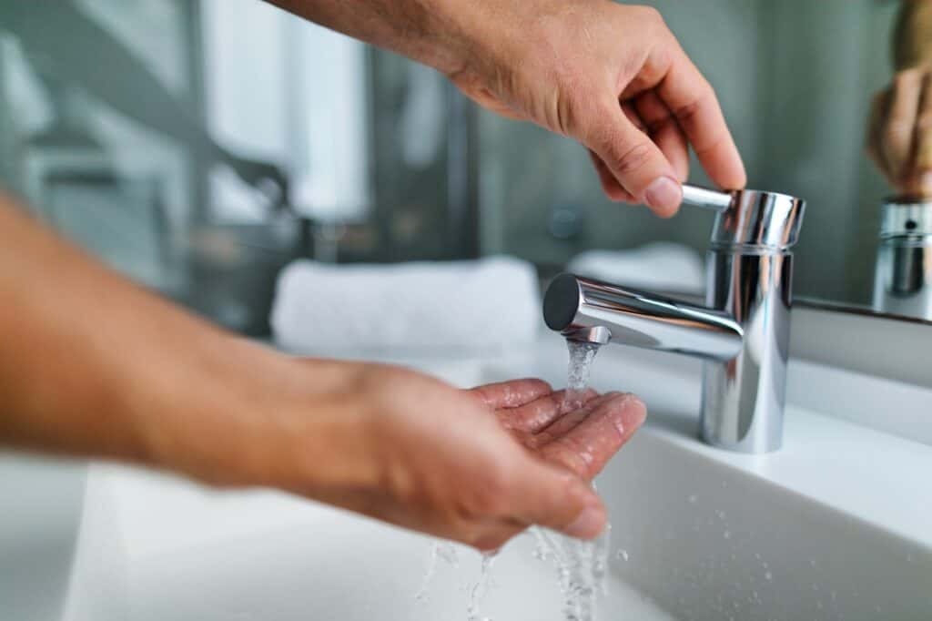 Cropped image of a man washing his hands with water